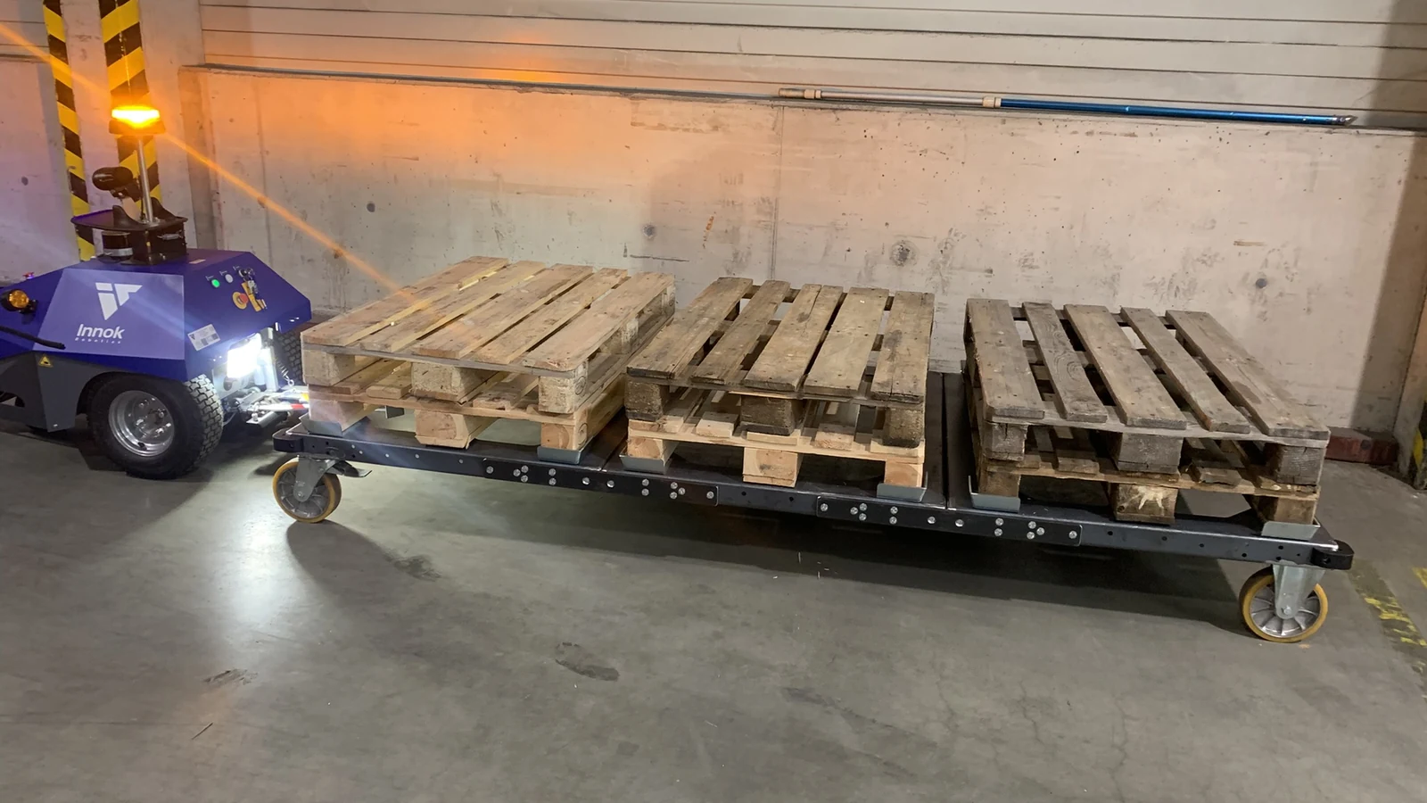 INDUROS mit dreiteiligem Plattformzug und Paletten als sichtbarer Testladung in einer Halle