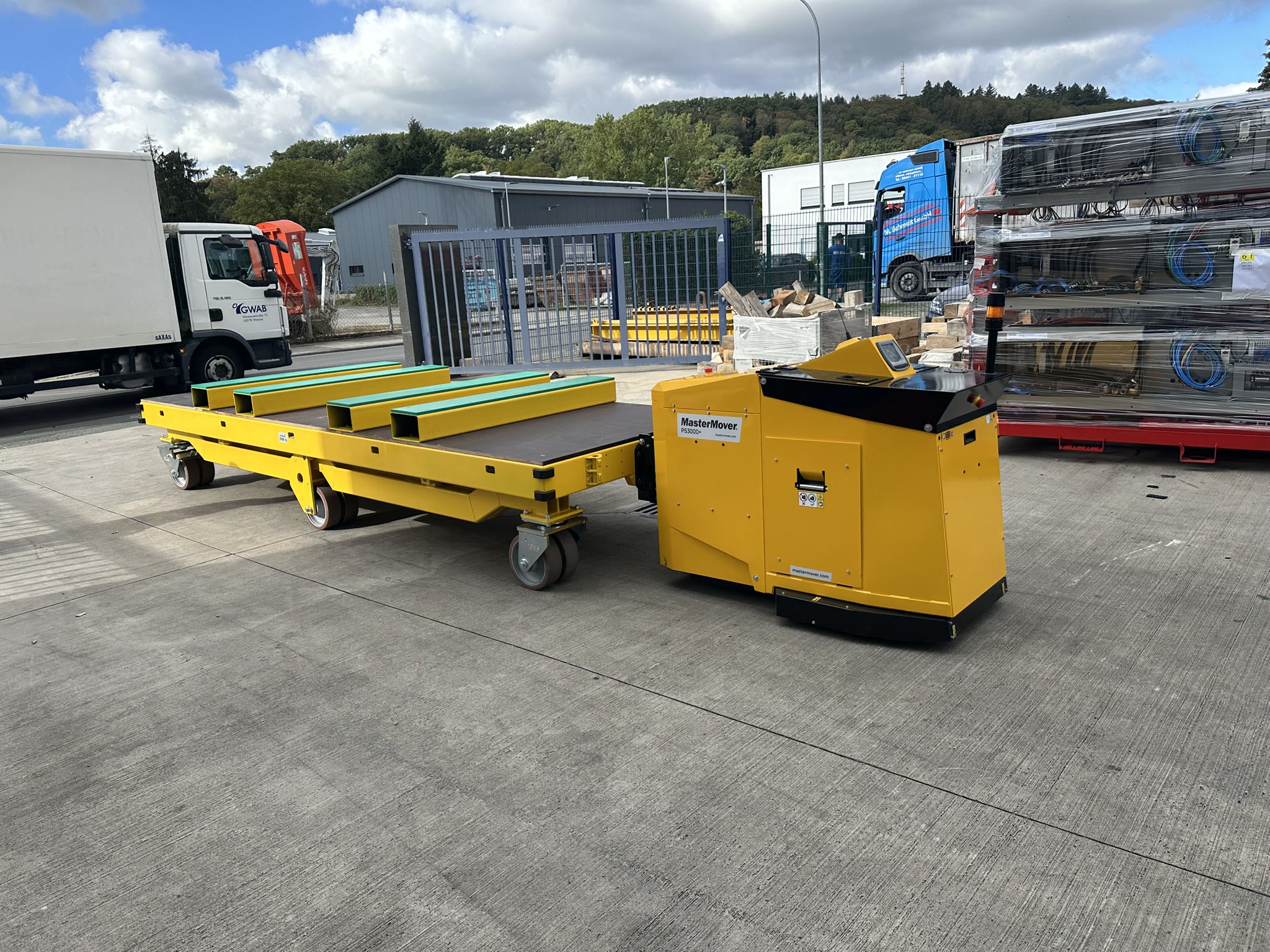 Gelber kundenspezifischer Flipper X-Move von MK-Lietz im Verbund mit einem gelben MasterMover-Elektroschlepper auf einem Betriebshof.