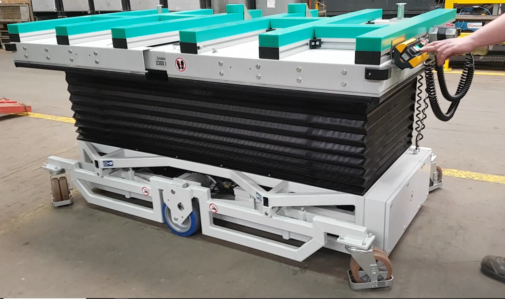 Flipper ExtendMax E mit angehobener Plattform, grünen Auflagen, schwarzem Faltenbalg und kabelgebundener Bedienung.